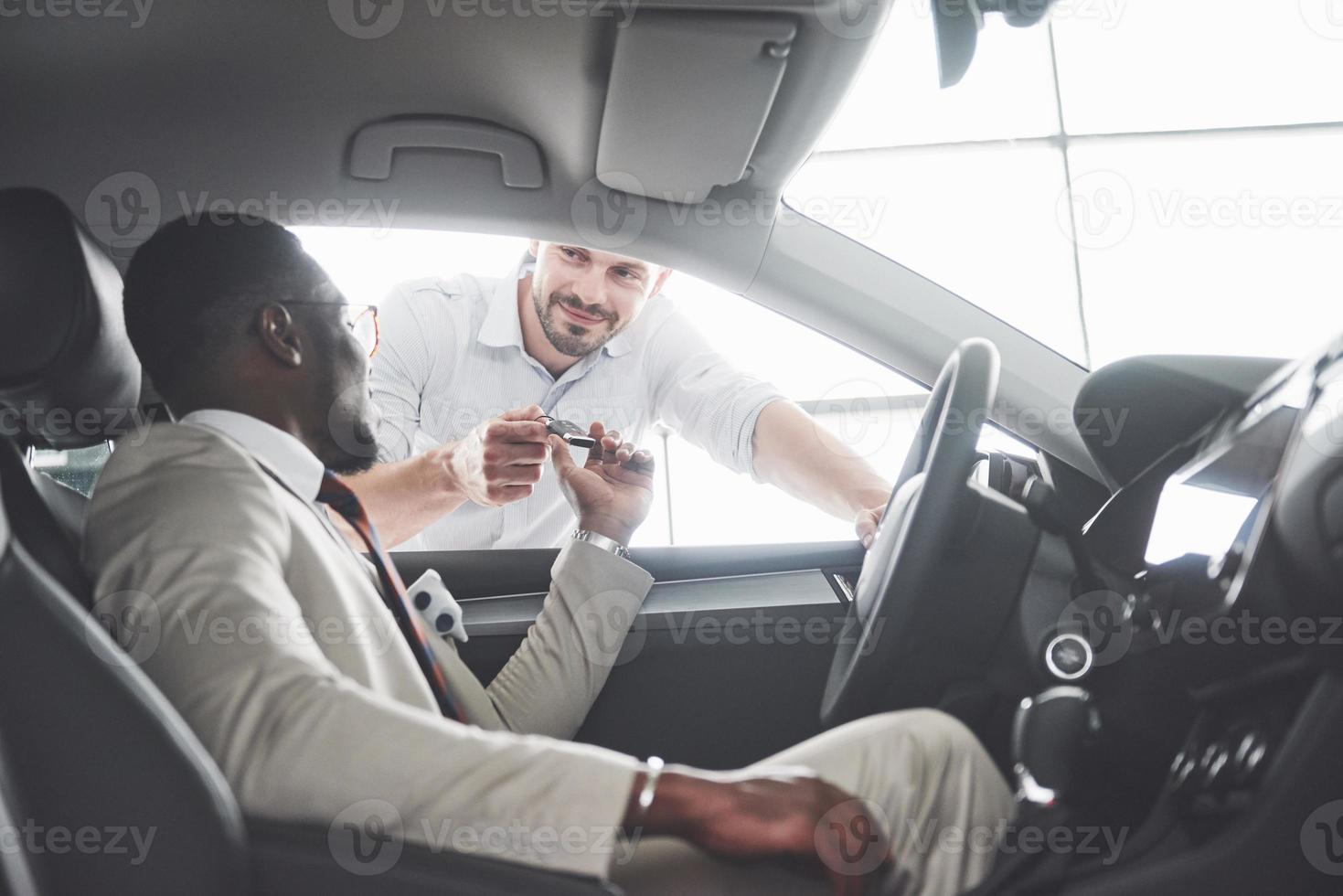 jovem empresário negro test drive novo carro. homem afro-americano rico foto