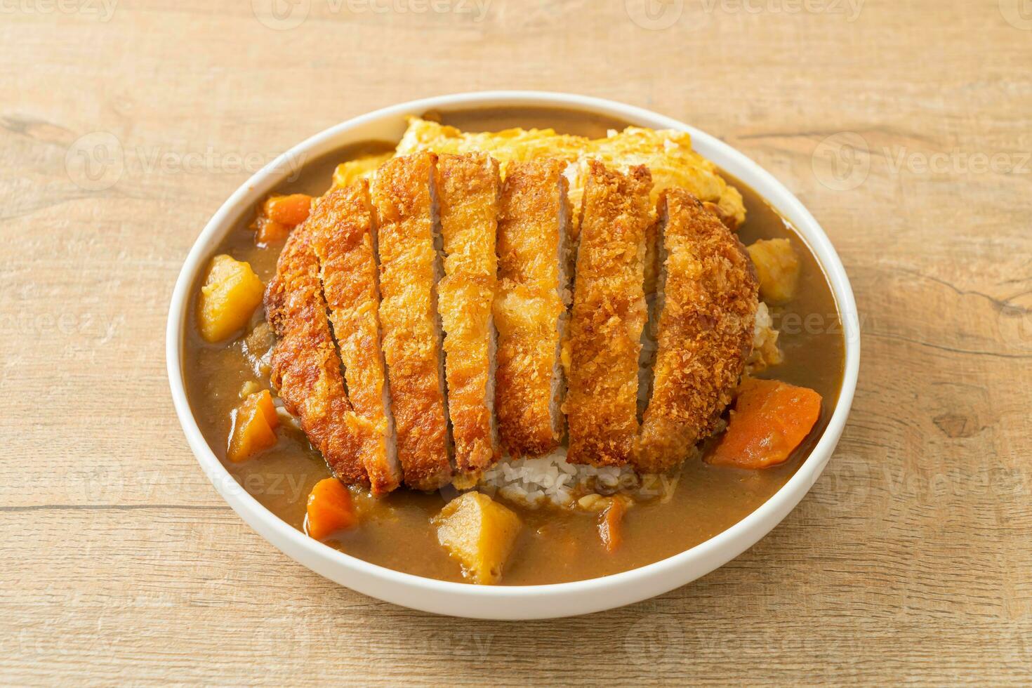 arroz de curry com costeleta de porco frita e omelete cremosa foto