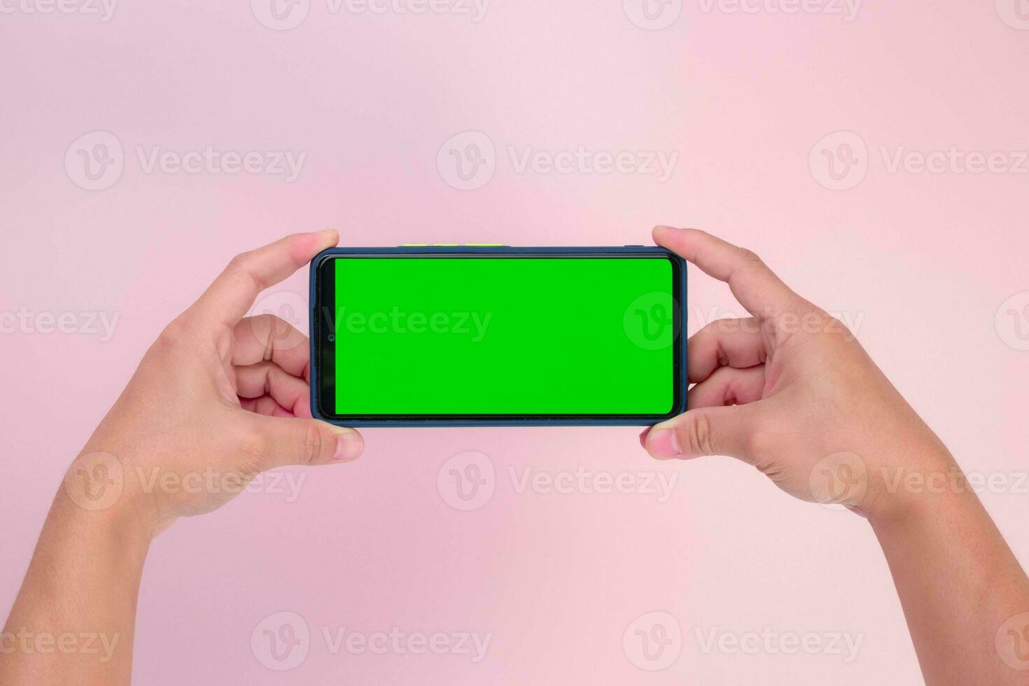 humano mão segurando Móvel Smartphone com verde tela dentro horizontal posição isolado em Rosa fundo. recorte caminho foto