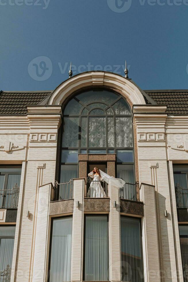 noiva com uma véu em a hotel sacada dentro uma Casamento vestir, cópia de espaço, livre espaço foto