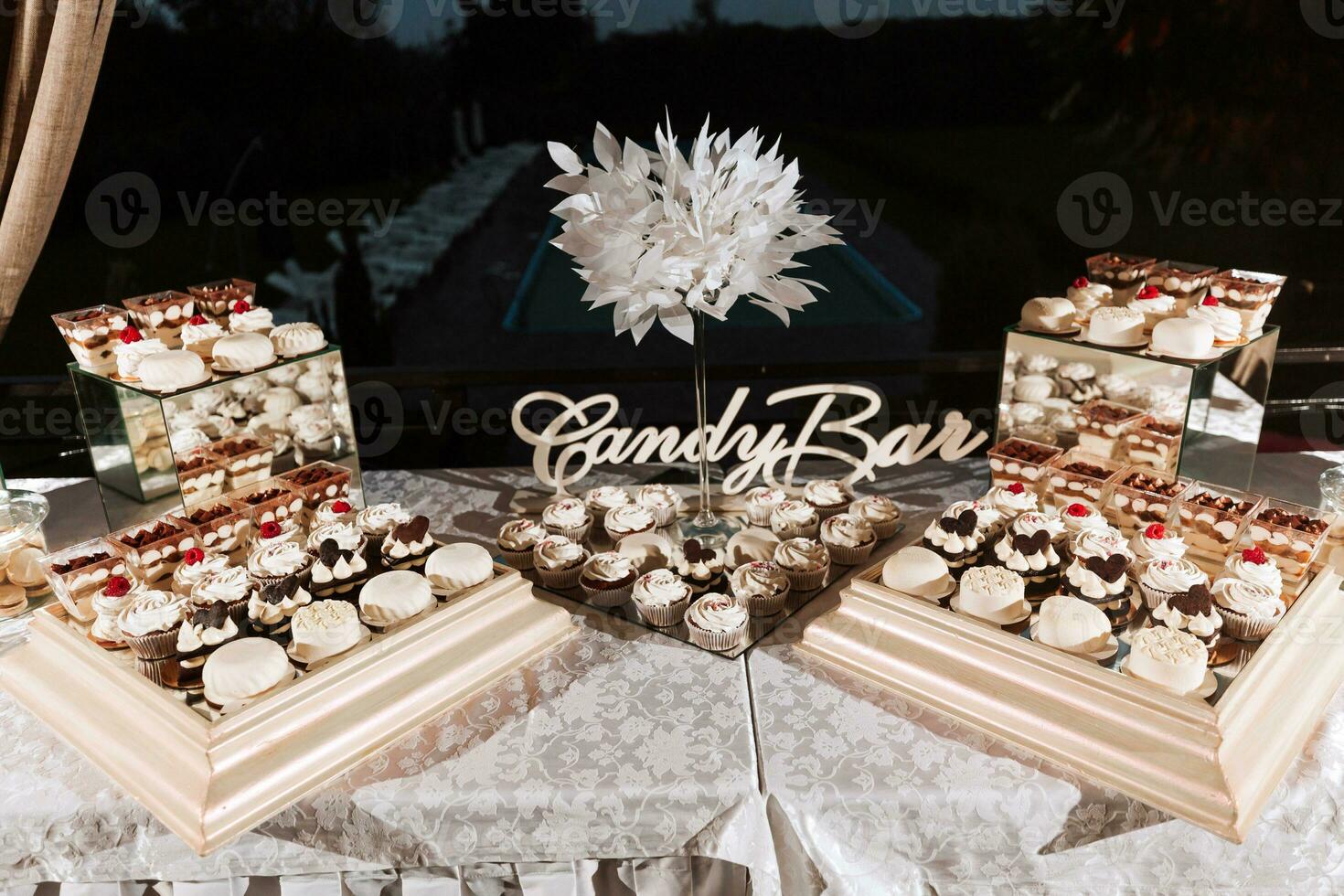 festivo sobremesa mesa com doces. Casamento doce bar, vários bolos, chocolates em fica. foto