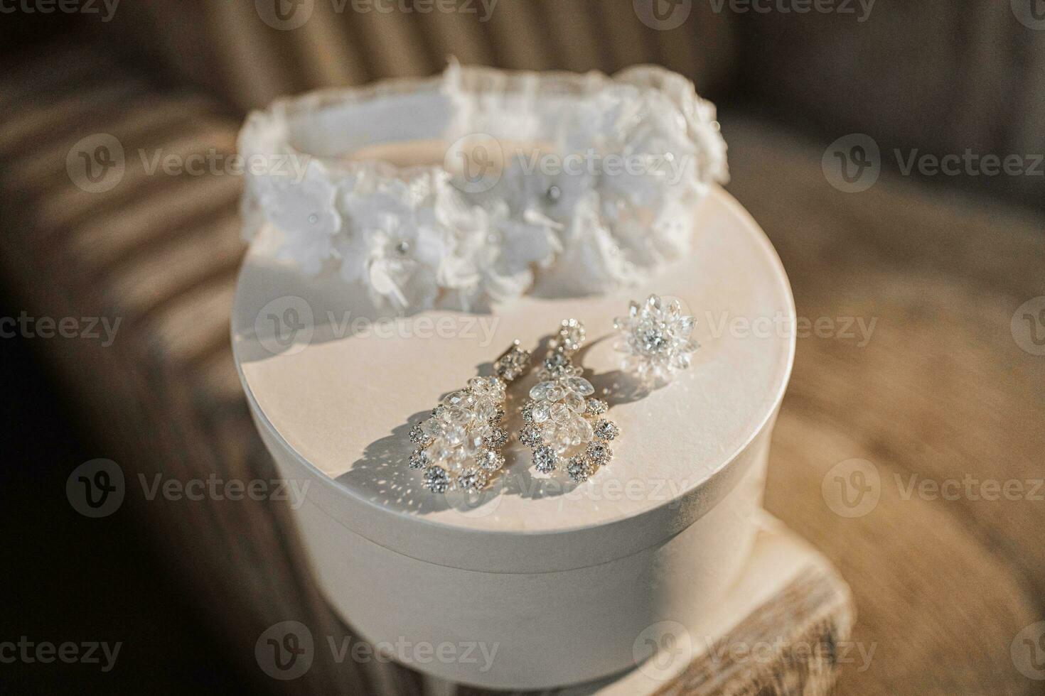 uma branco Casamento perna banda e elegante cristal brincos ficar de pé em uma branco volta cesta. presente caixa. Casamento detalhes foto