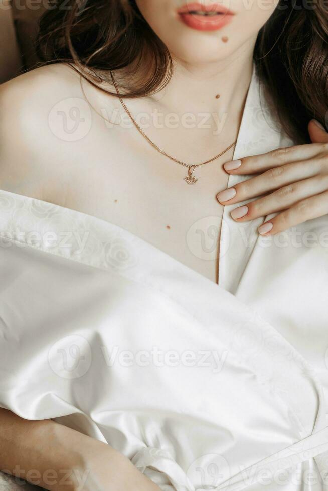 uma jovem menina mostra uma ouro pingente em dela pescoço dentro a Formato do uma coroa foto