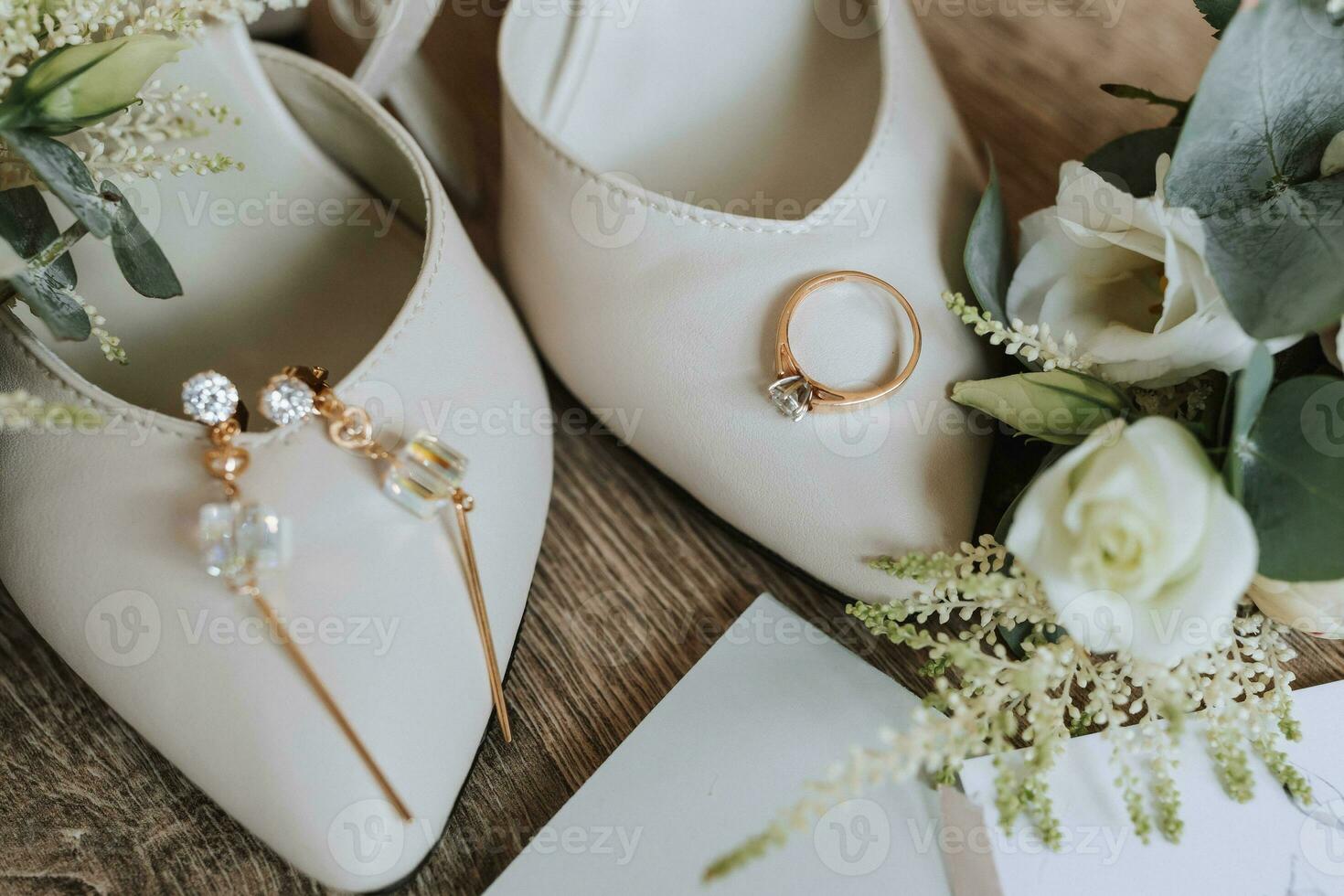 branco Casamento sapatos e detalhes do a noiva. Casamento anel com diamante e ouro pulseira com cristais, em de madeira fundo. flores e vegetação. Casamento tema foto