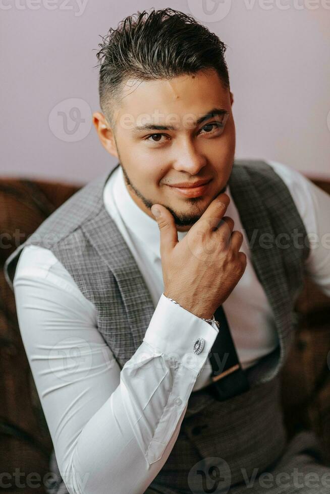 retrato do uma homem com uma barba dentro uma clássico terno. a noivo é preparando para a casamento. a homem desgasta uma branco camisa. à moda noivo foto