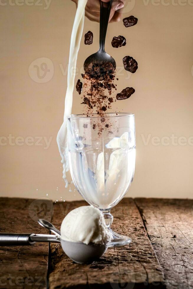 gelo creme dentro uma vidro em uma de madeira mesa com uma colher e chocolate salgadinhos foto