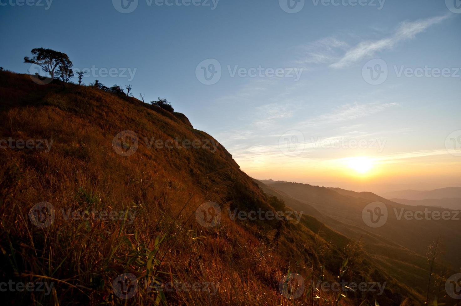 lindo nevoeiro e nascer do sol no topo da montanha foto