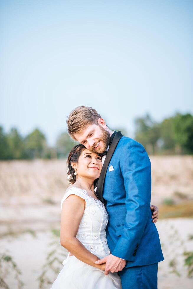 Noiva asiática e noivo caucasiano têm tempo de romance e felizes juntos foto