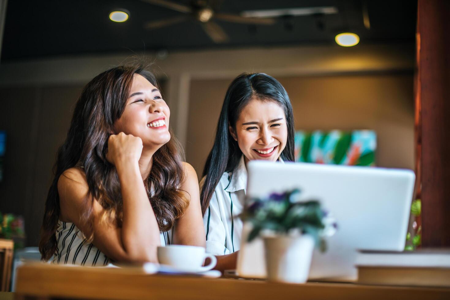 duas lindas mulheres conversando sobre tudo em uma cafeteria foto