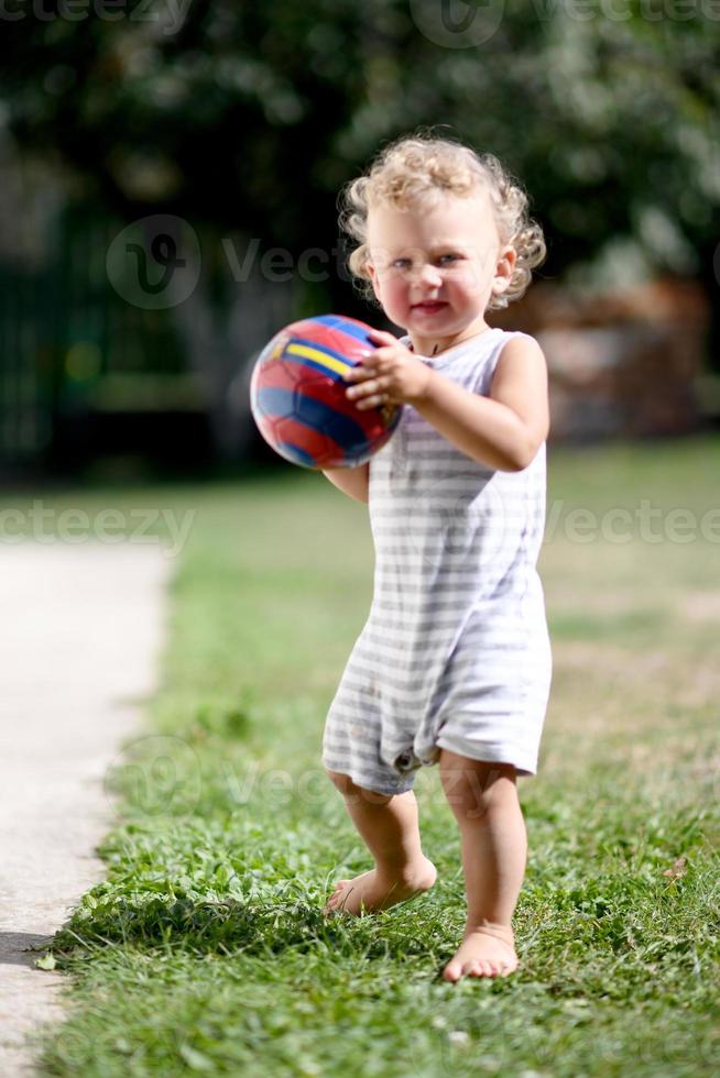 lindo menino com bola de brinquedo criança posando fotógrafo foto