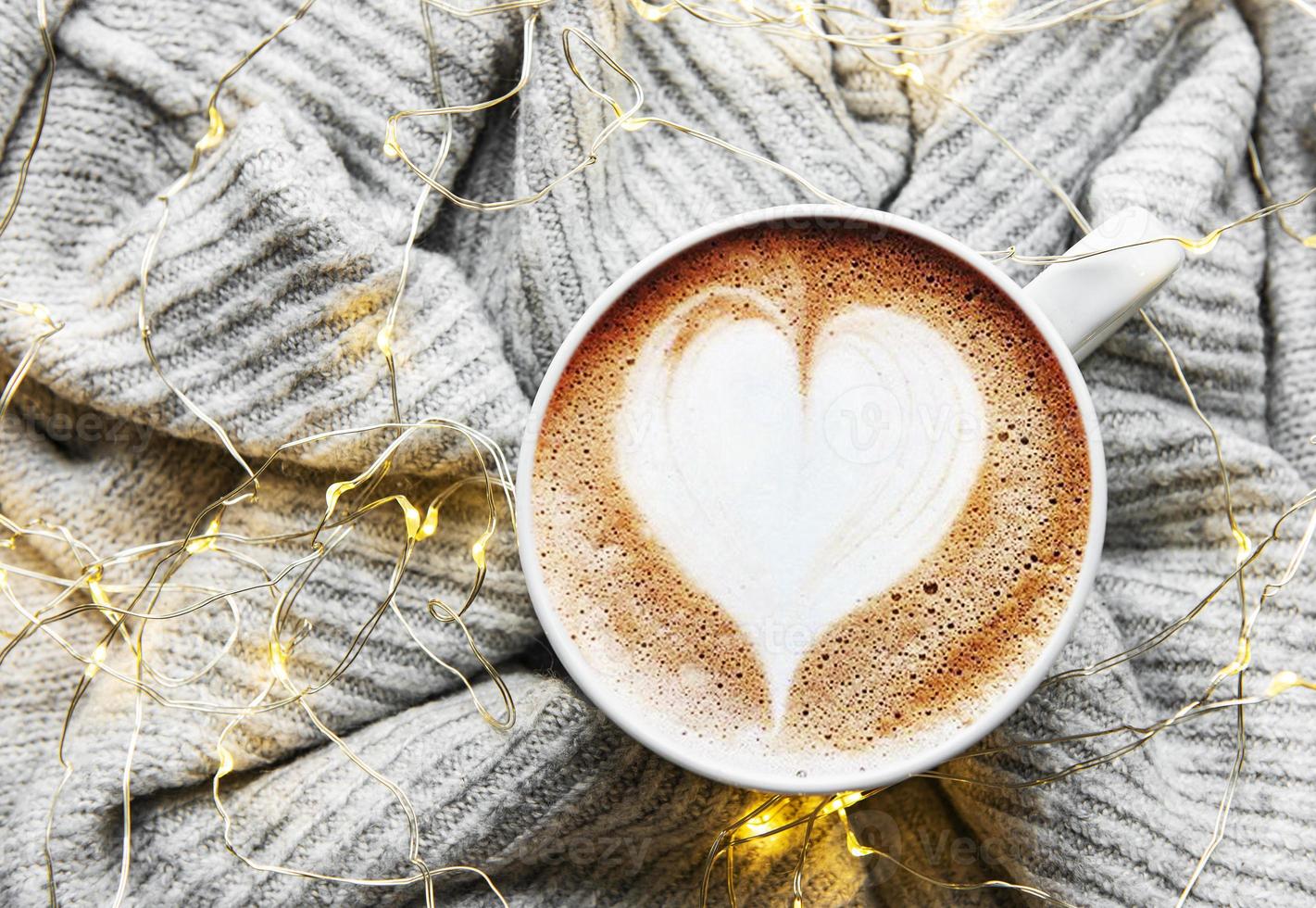 café com padrão de coração em um suéter de tricô quente foto