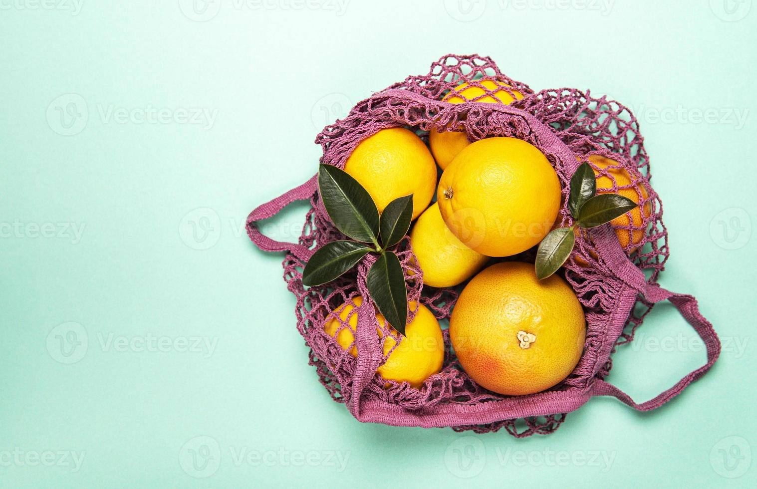 sacola de compras de malha com laranjas foto