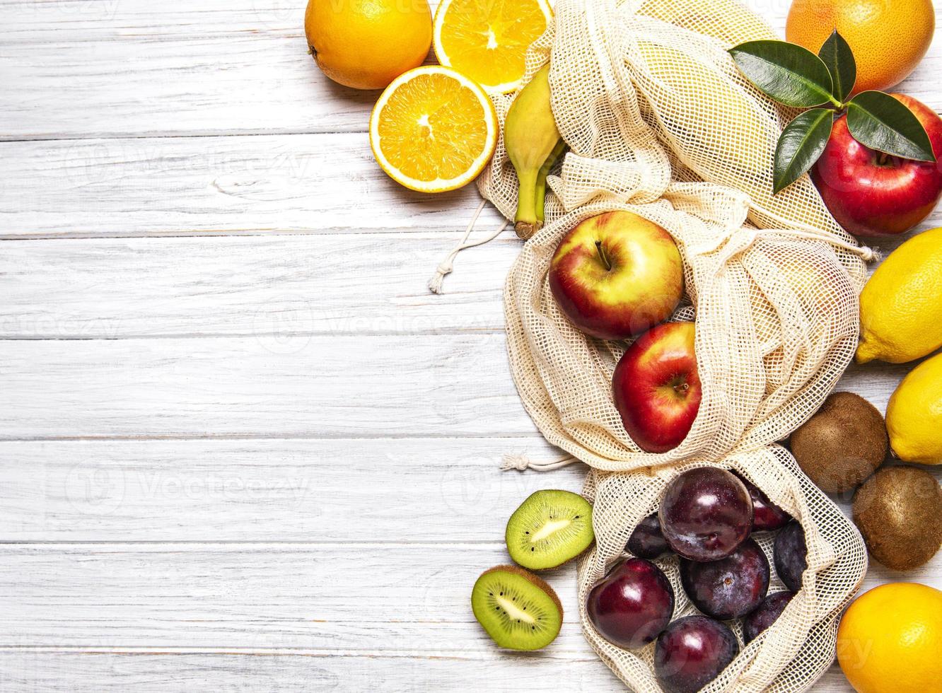 malha sacolas de compras com frutas foto