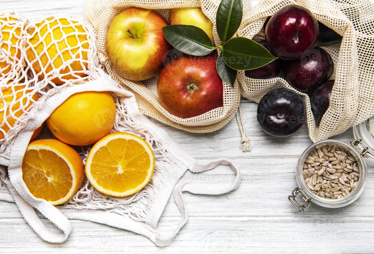 malha sacolas de compras com frutas foto