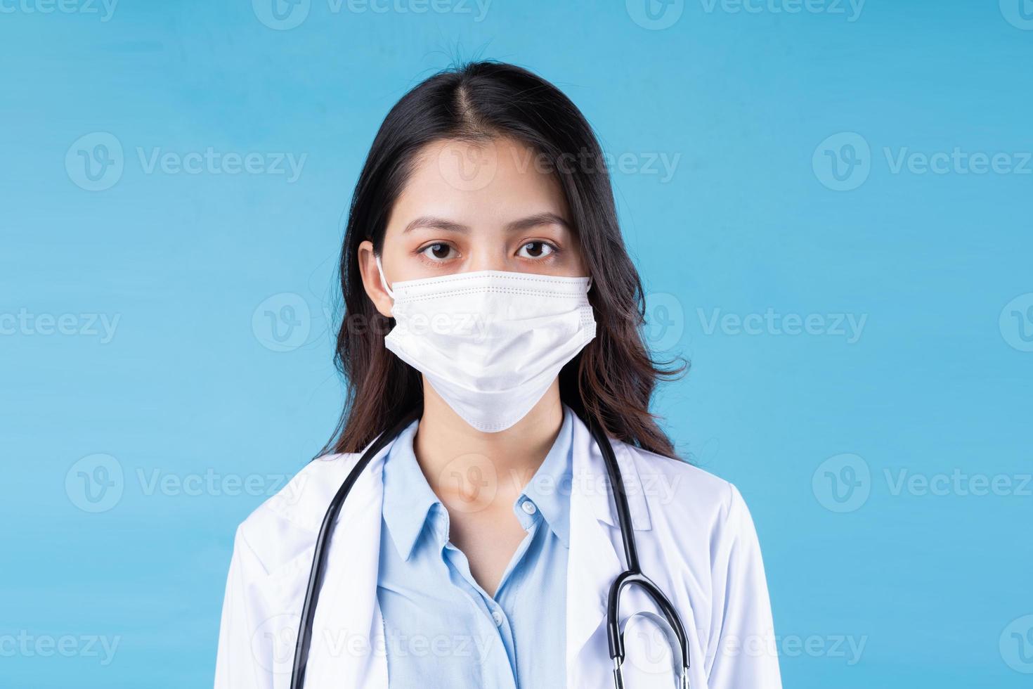 retrato de jovem médica, isolado sobre fundo azul foto