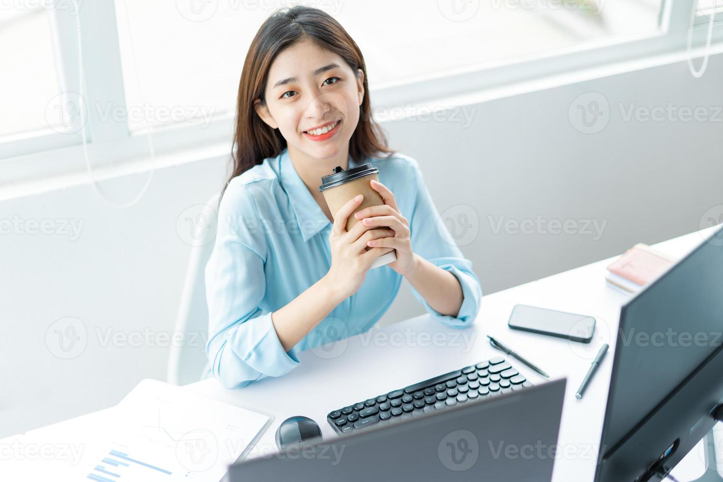 retrato de uma jovem mulher de negócios segurando uma xícara de café foto