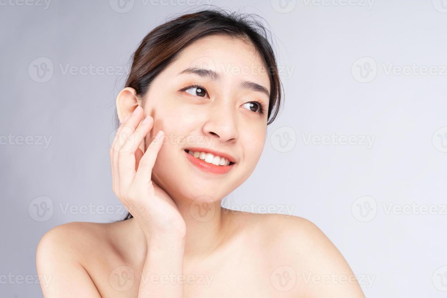 bela jovem asiática com pele limpa, fresca, sobre fundo branco, foto