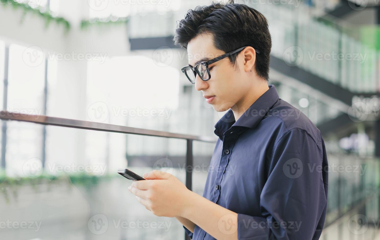 homem de negócios asiático usando telefone no trabalho foto