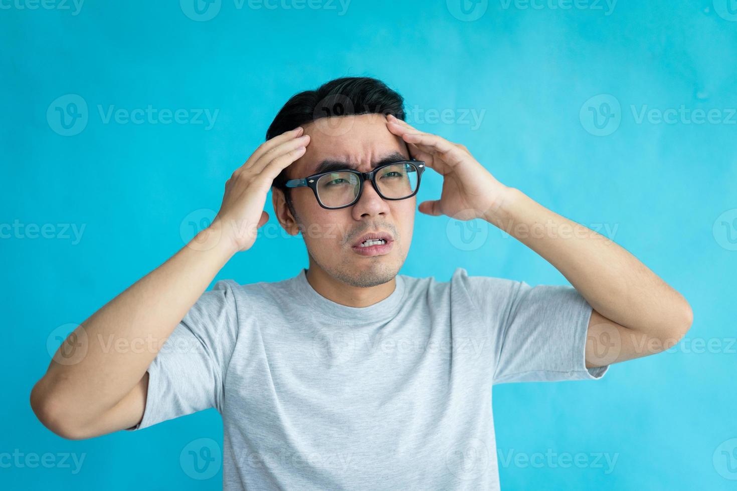 retrato de homem com dor de cabeça, isolado em fundo azul foto