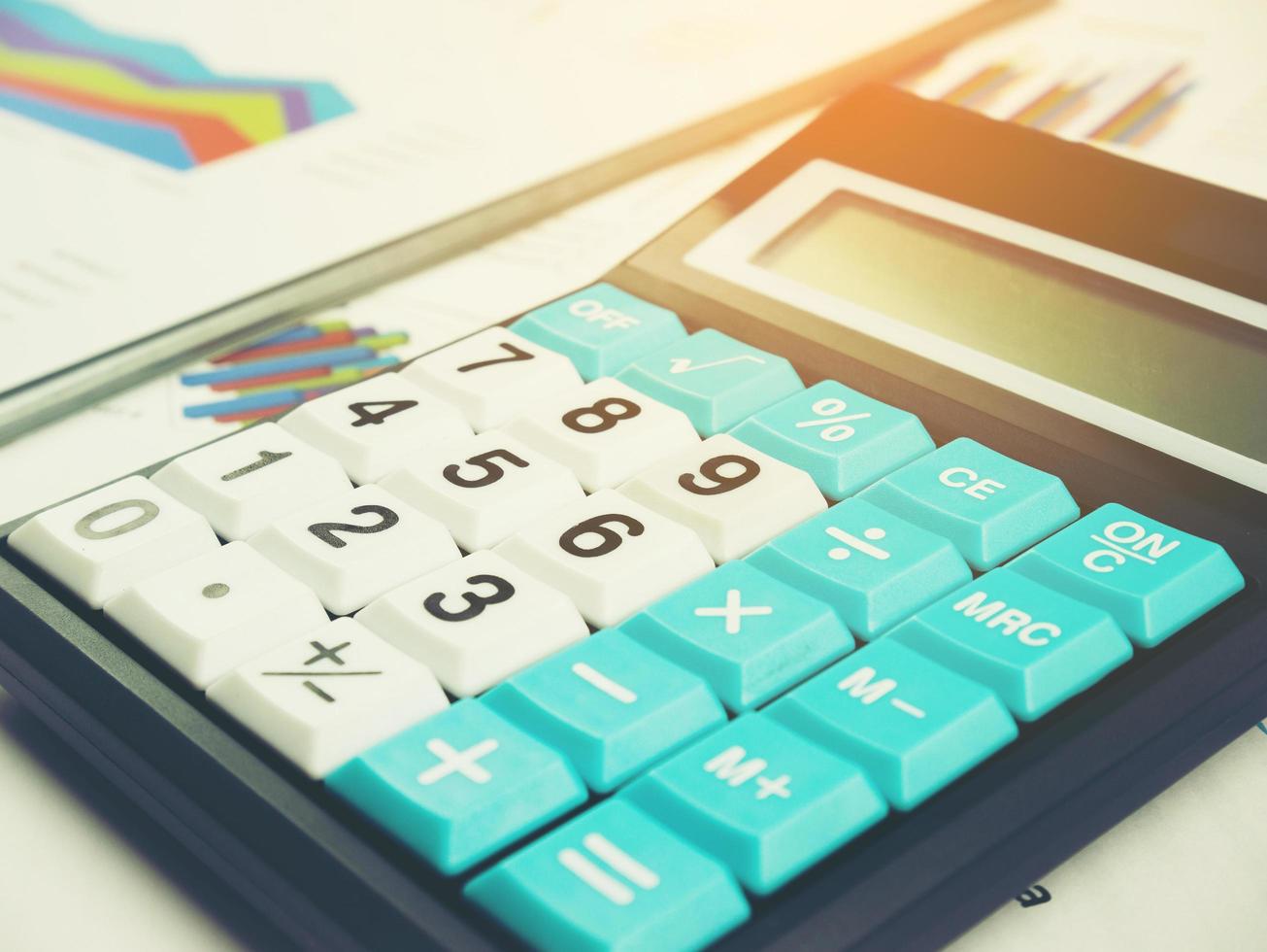 gráfico de marketing de negócios e relatório de gráfico de análise financeira com calculadora no fundo da mesa de madeira foto