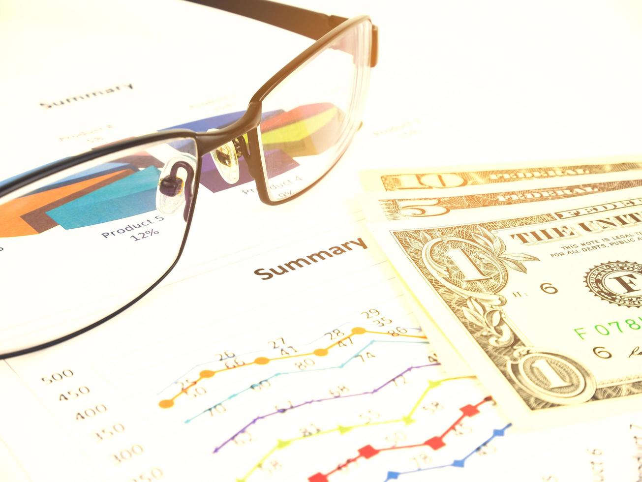 gráfico de negócios perto de dólares por óculos fora de foco, conceito financeiro foto