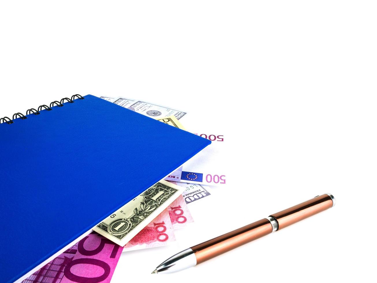 livro azul com notas internacionais aninhadas, isoladas no fundo branco. stash of money concept, business ideas foto