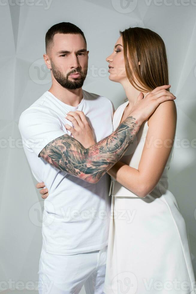 retrato do uma lindo jovem casal dentro amor posando às estúdio sobre branco fundo. foto
