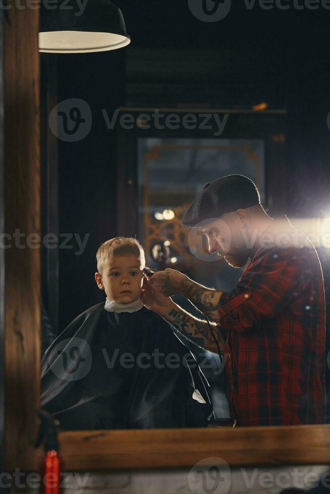 caucasiano Garoto obtendo corte de cabelo dentro barbearia interior foto