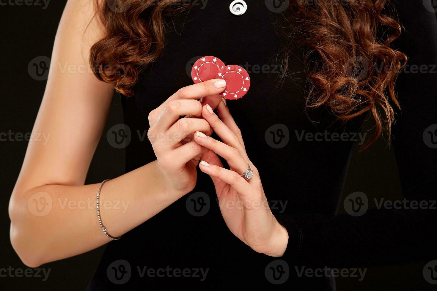 sexy encaracolado cabelo morena posando com salgadinhos dentro dela mãos, pôquer conceito Preto fundo foto