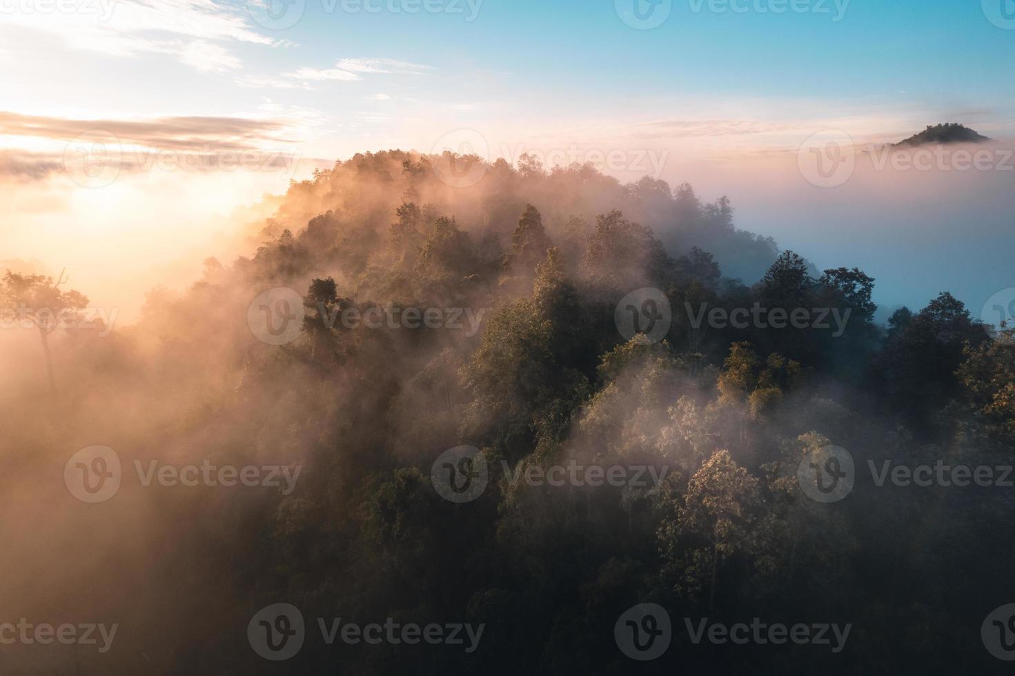 o sol nasce na névoa e as montanhas pela manhã foto