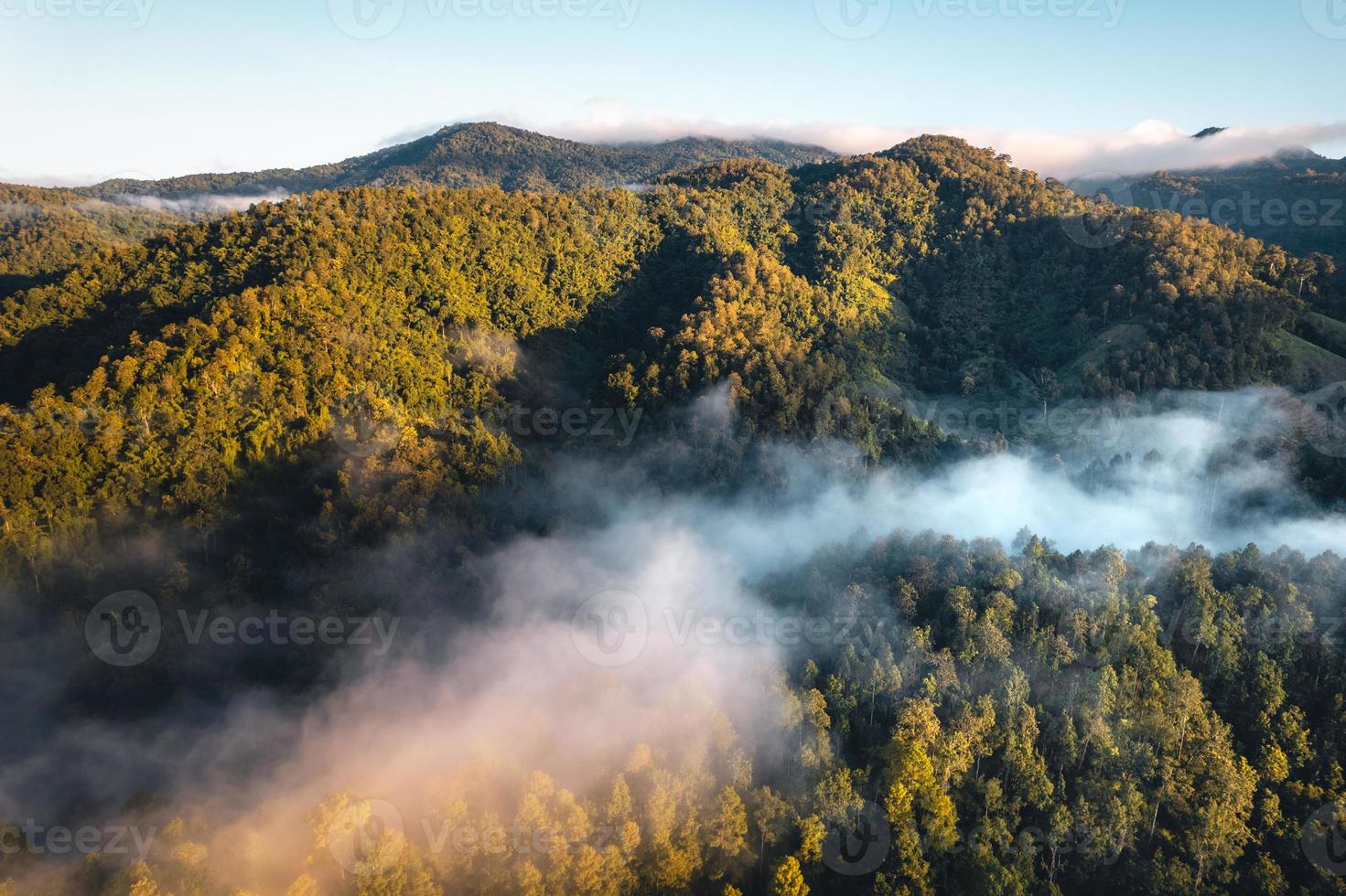 o sol nasce na névoa e as montanhas pela manhã foto