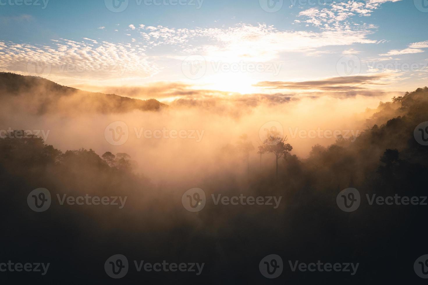 o sol nasce na névoa e as montanhas pela manhã foto