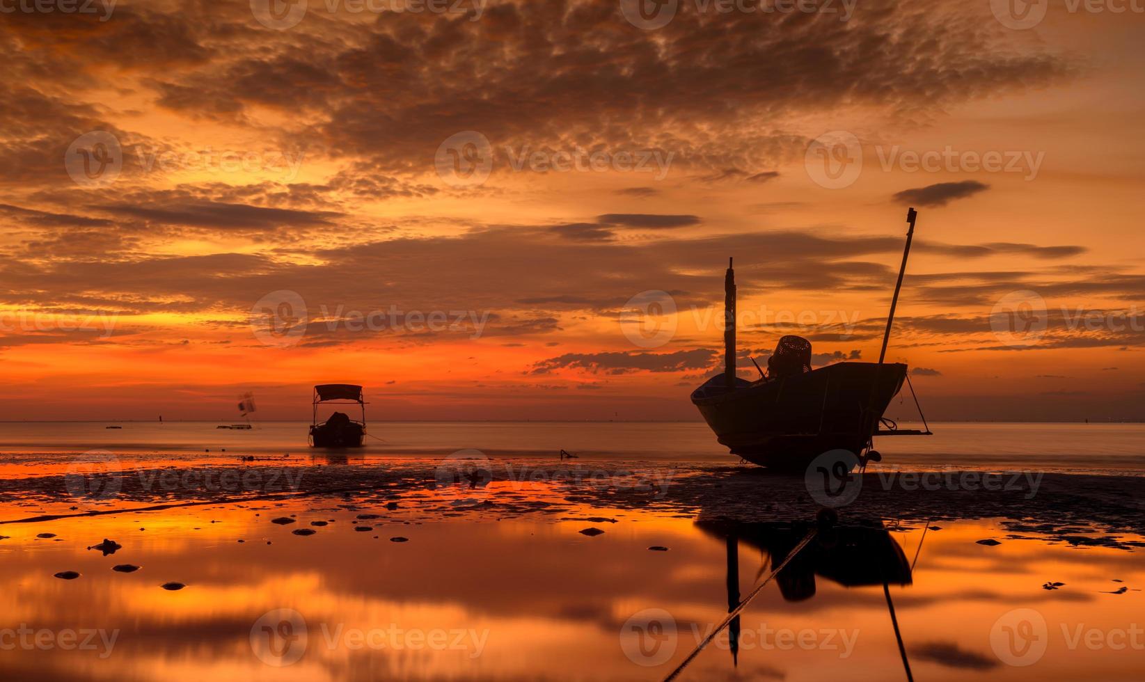 silhueta pesca barco de madeira com luz do sol do céu baixa. foto