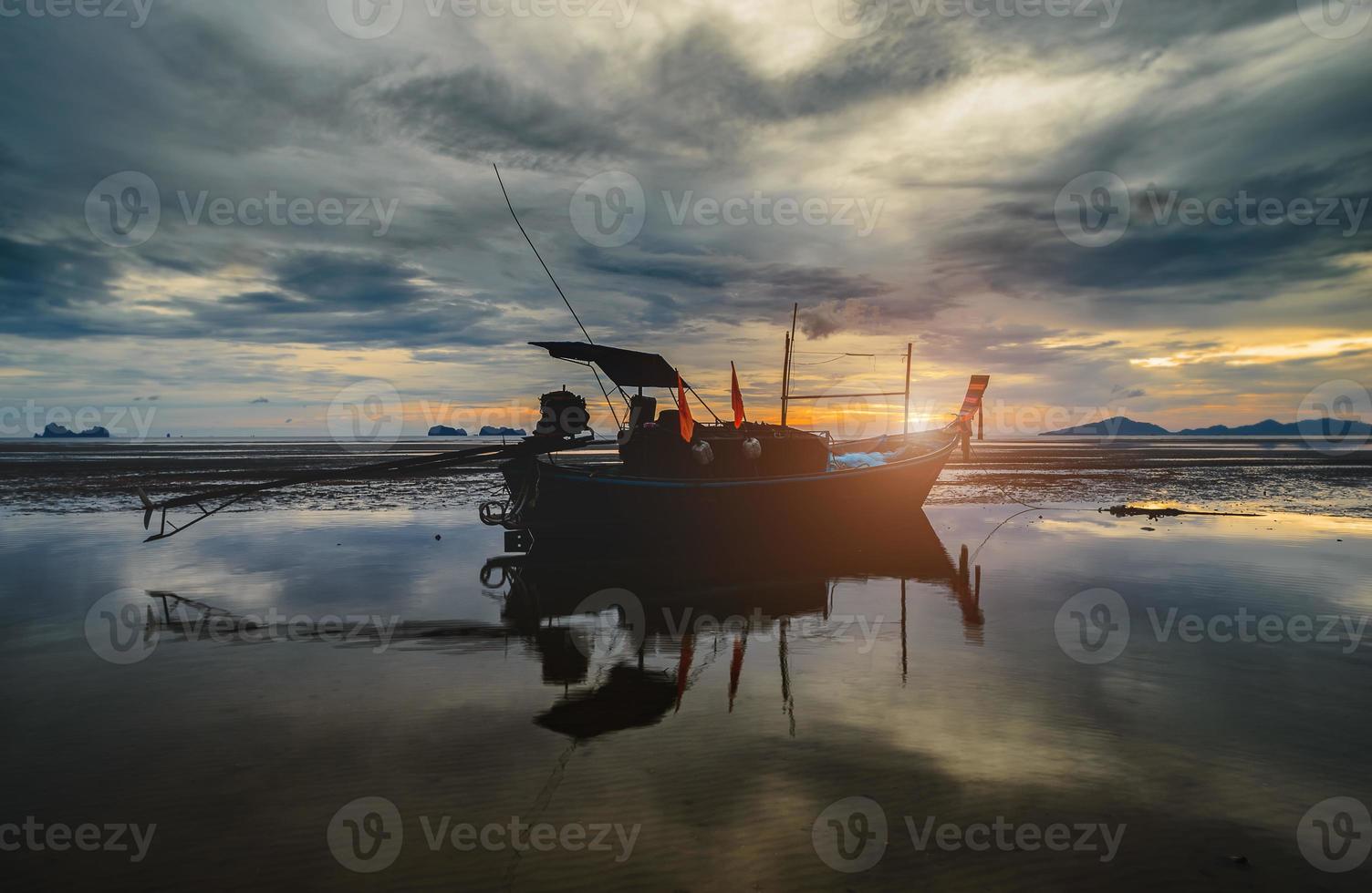 barco de pesca de madeira com iluminação baixa do céu do sol. foto