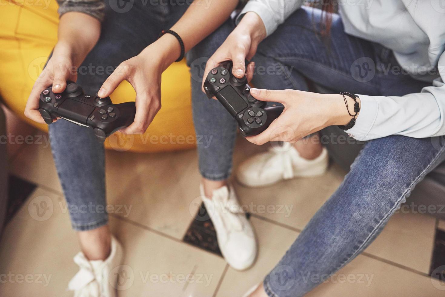 irmãs gêmeas jogam no console. meninas seguram joysticks nas mãos e se divertem foto