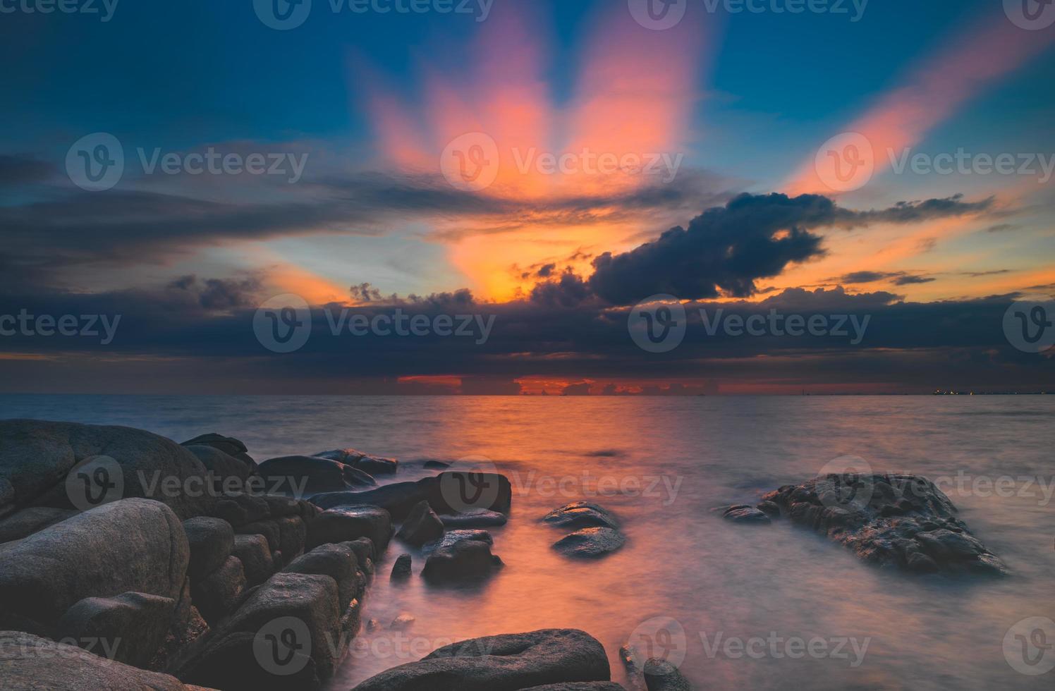 as pedras no mar com céu de nuvem. foto