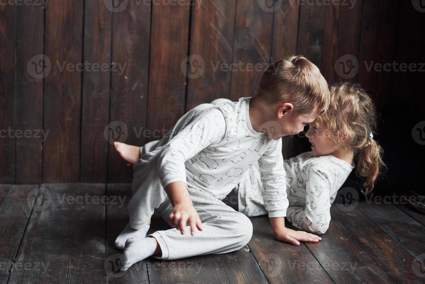 dois filhos, irmão e irmã de pijama brincam juntos foto