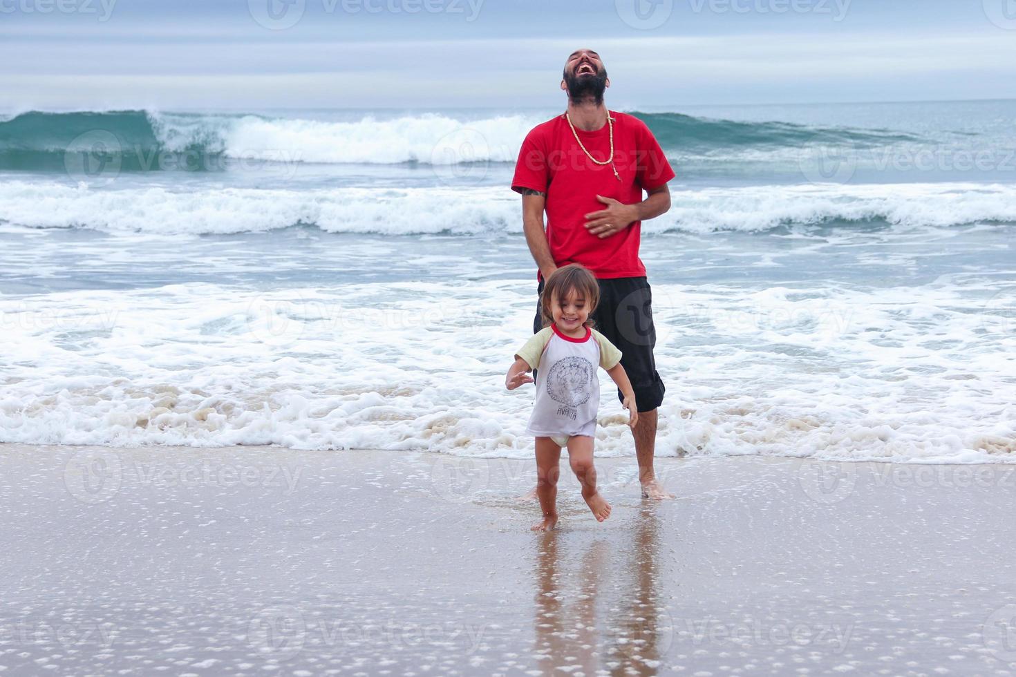 pai e filho brincando juntos na praia foto