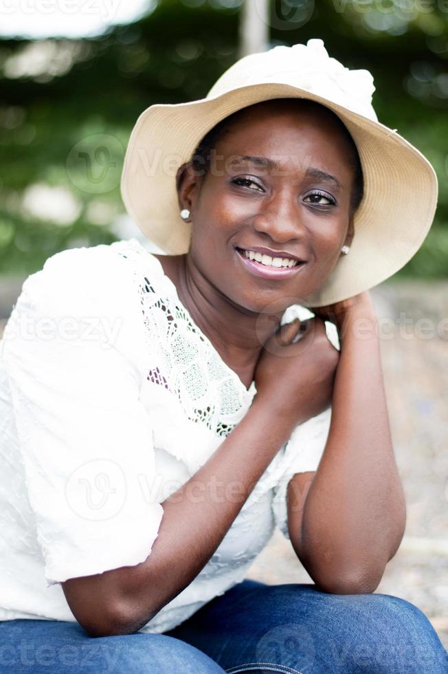 bela mulher sorridente, sentada do lado de fora. foto