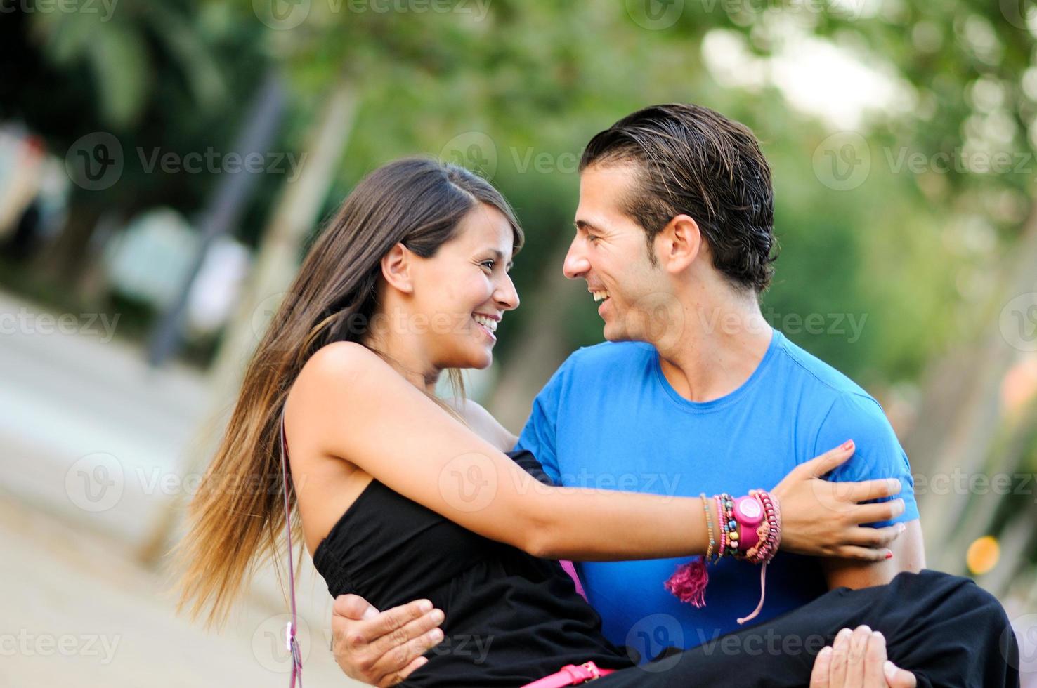 casal apaixonado se abraçando ao ar livre no parque parecendo feliz foto