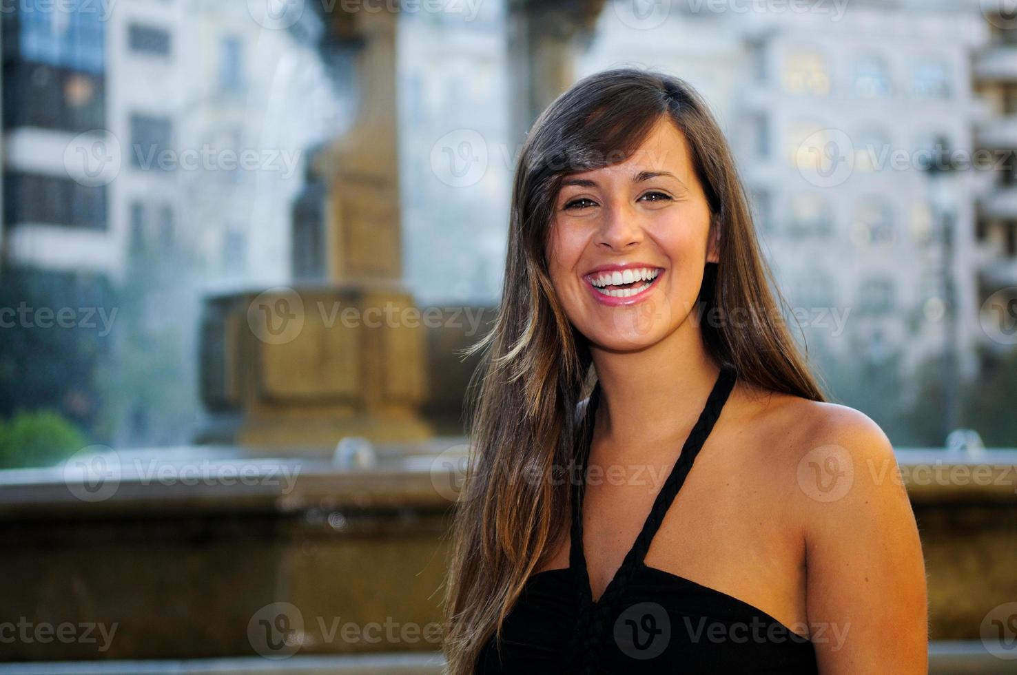retrato de mulher sorridente atraente em meio urbano foto