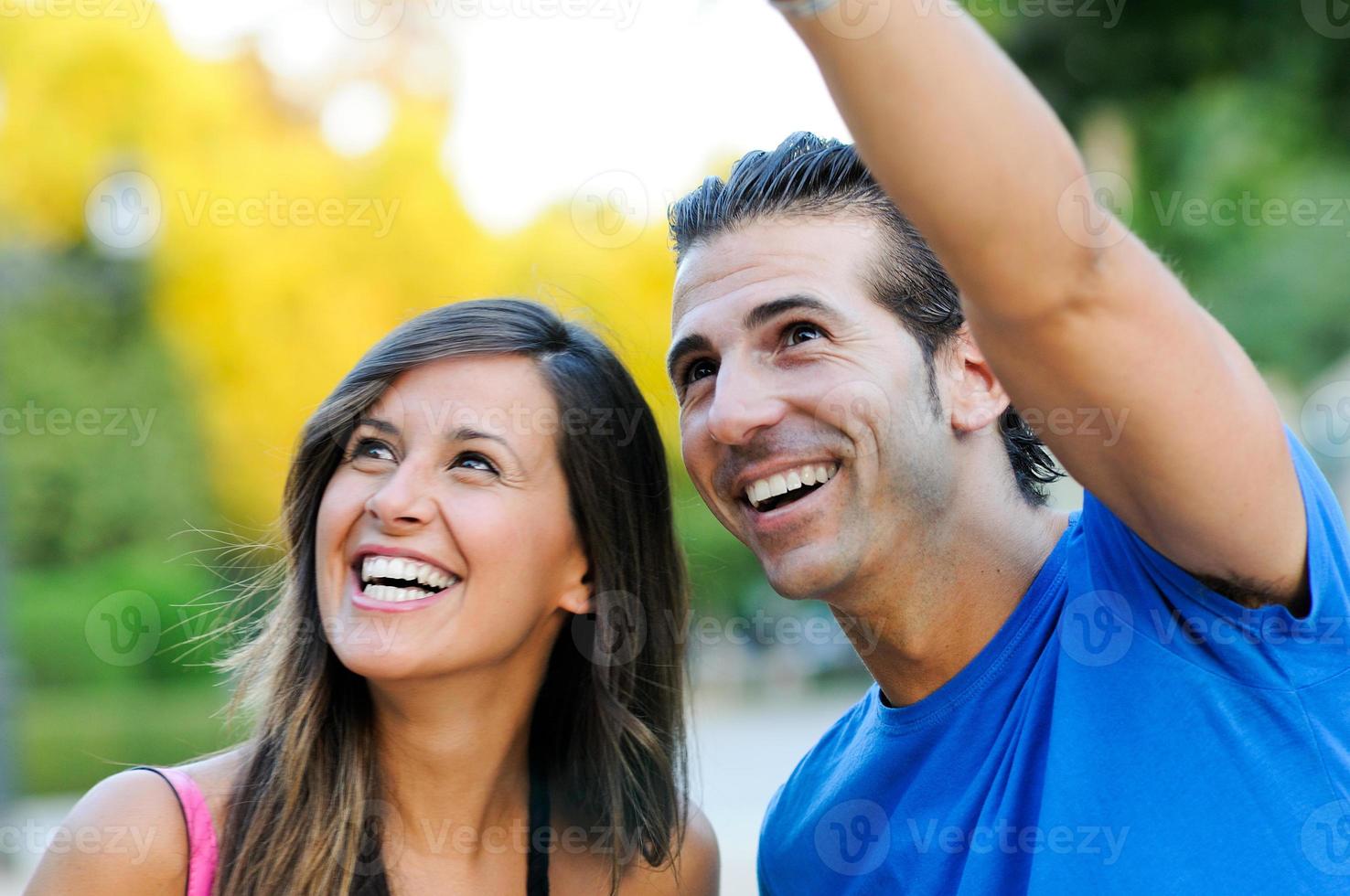 jovem casal feliz olhando para algo interessante - copyspace foto