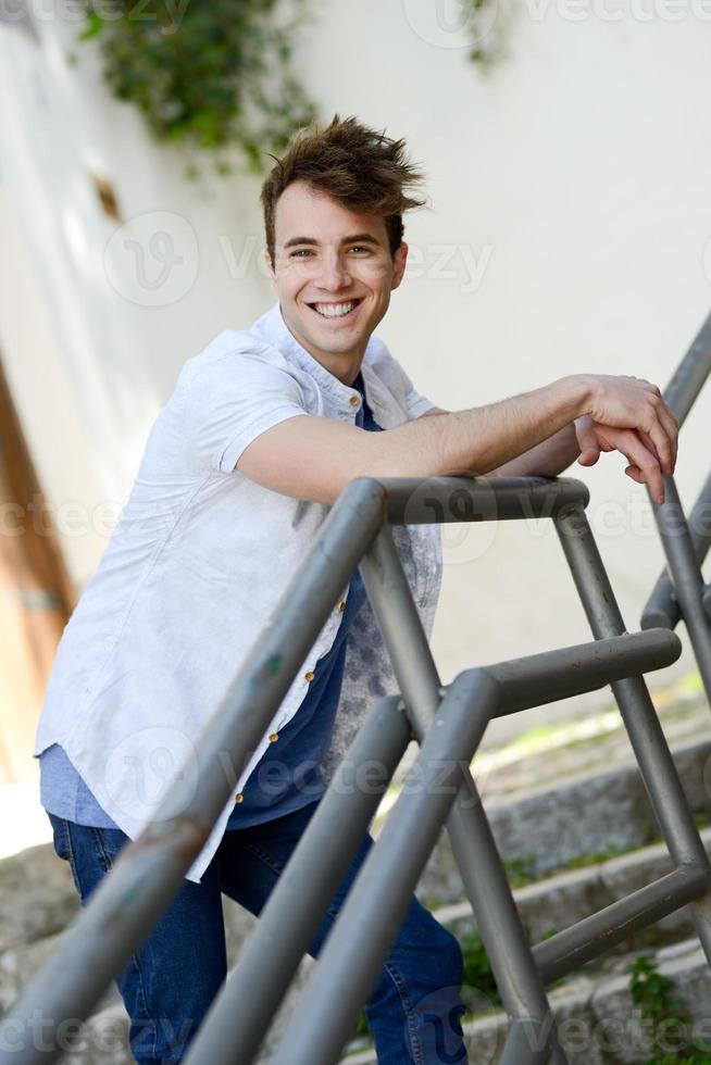 jovem atraente sorrindo em meio urbano foto