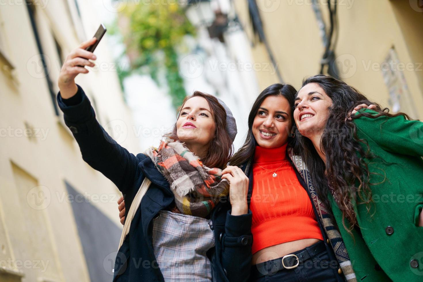 grupo de três mulheres felizes caminhando juntos ao ar livre foto