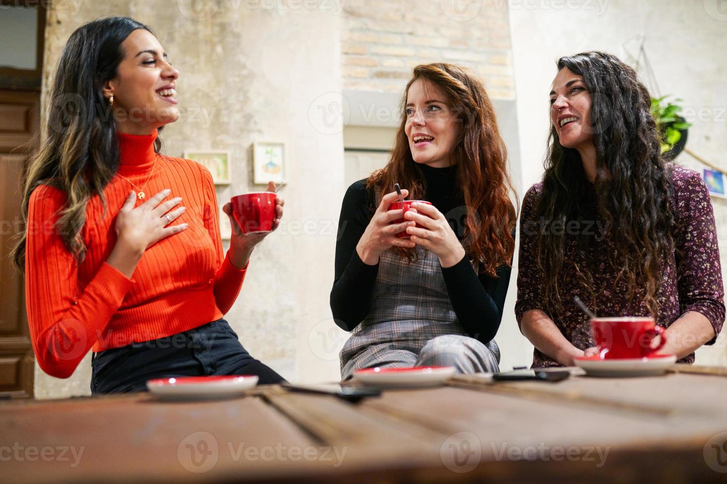 grupo de três amigos felizes bebendo café em um café-bar. foto