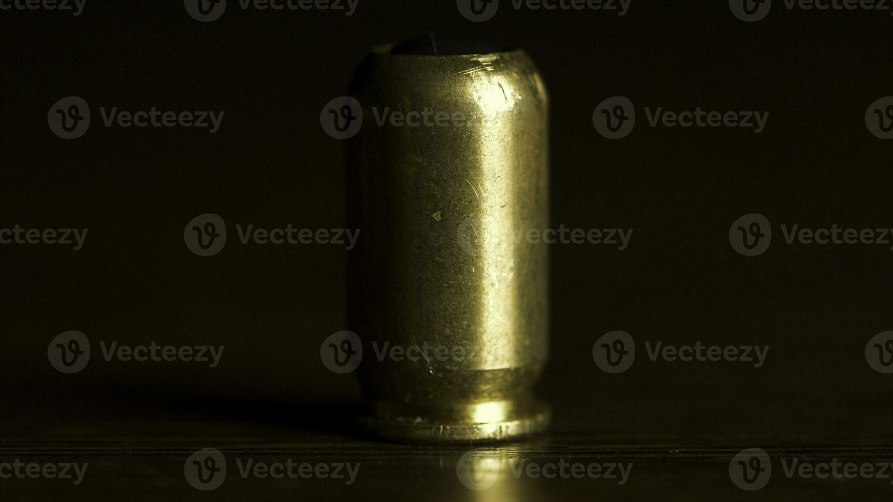 bala a partir de a arma de fogo colocada em uma de madeira mesa em Preto fundo, macro. 1 bala em a mesa para proteger ou assassinato pessoas foto