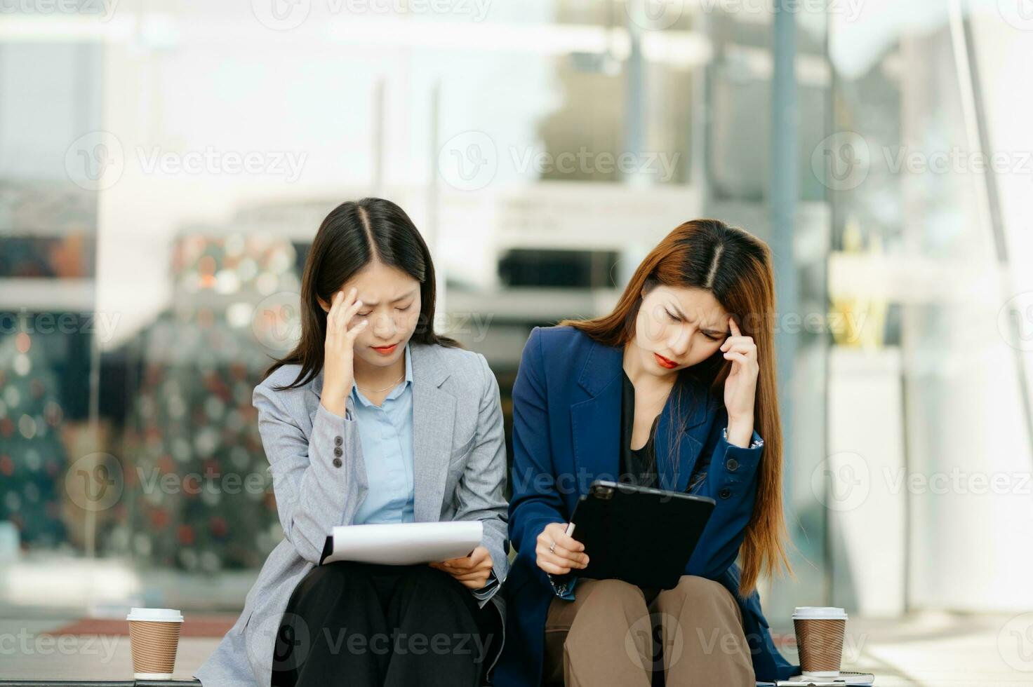 empresária e mulher indo dentro cidade Centro dentro inteligente casual o negócio estilo, conversando, trabalhando junto, à moda freelance pessoas, segurando tábua foto