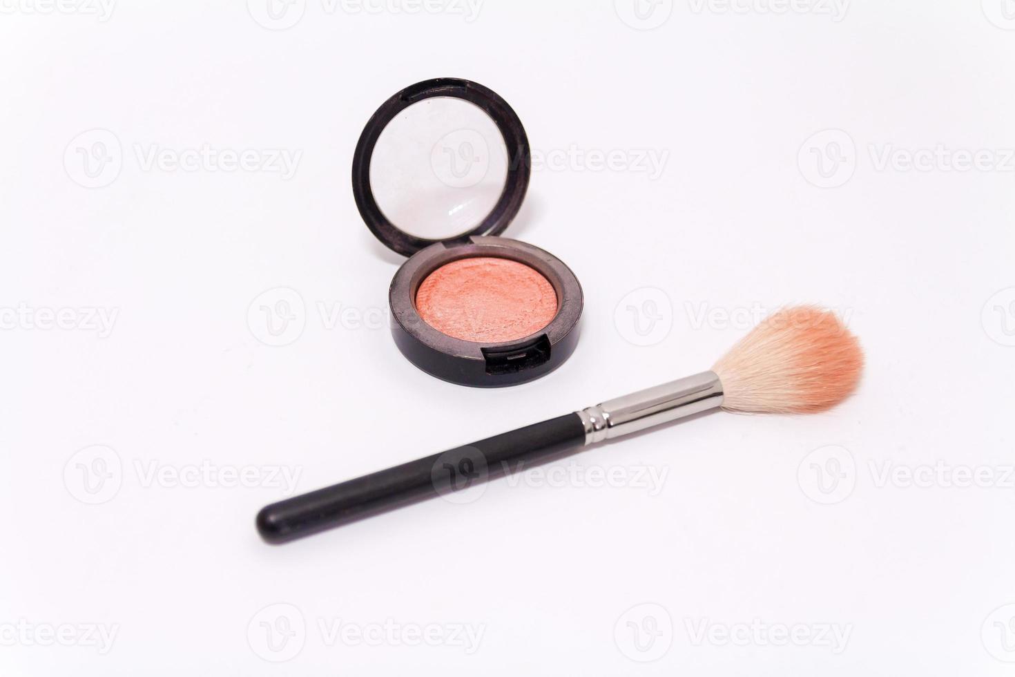 close-up do pincel de maquiagem e da caixa de blush isolado no fundo branco foto