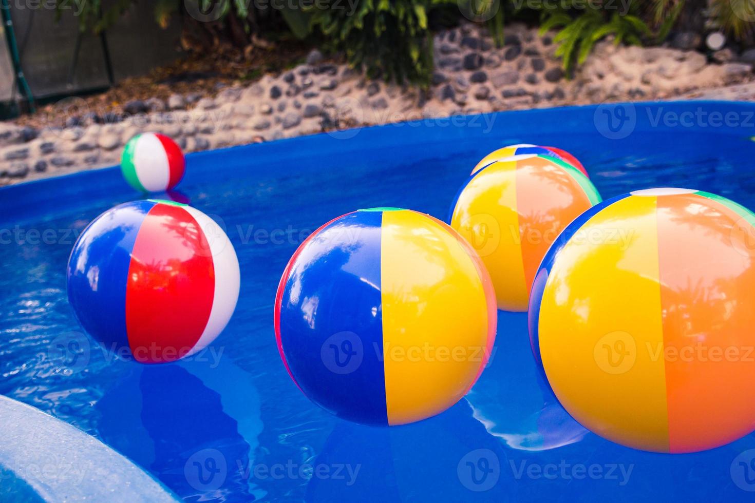 bolas de praia coloridas flutuando na piscina foto