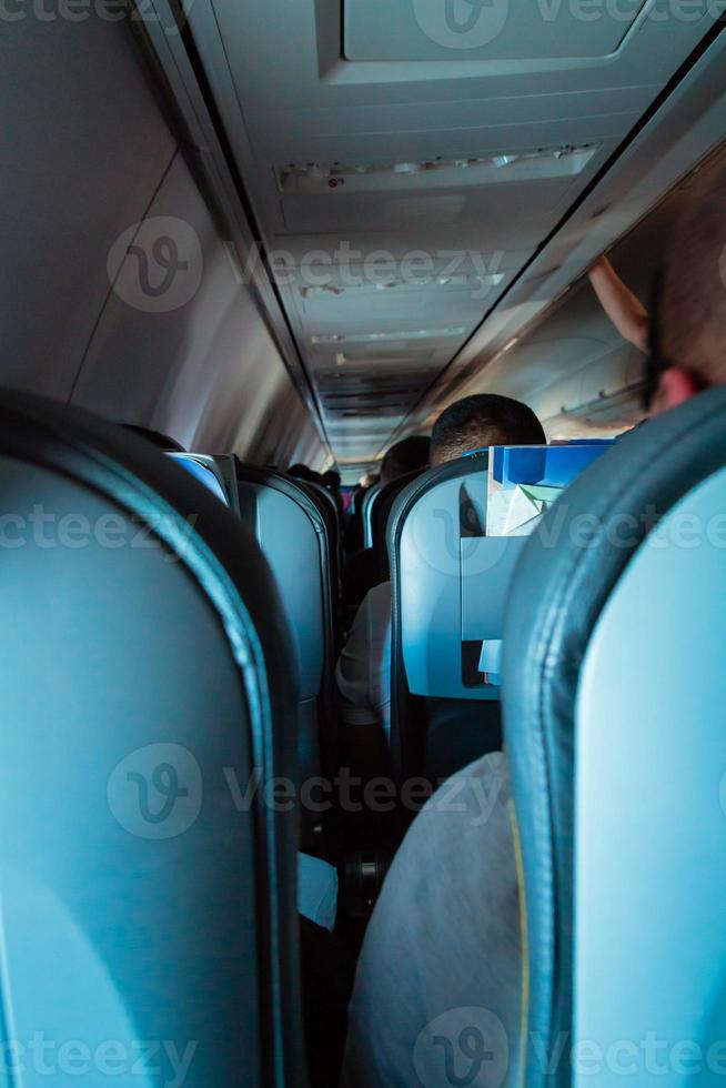 interior do avião de passageiros com pessoas nos assentos foto
